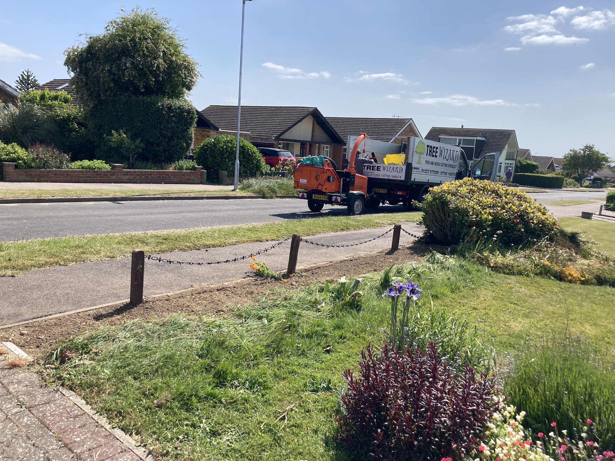 Tree Wizard van and orange chipper parked on a Seaford road