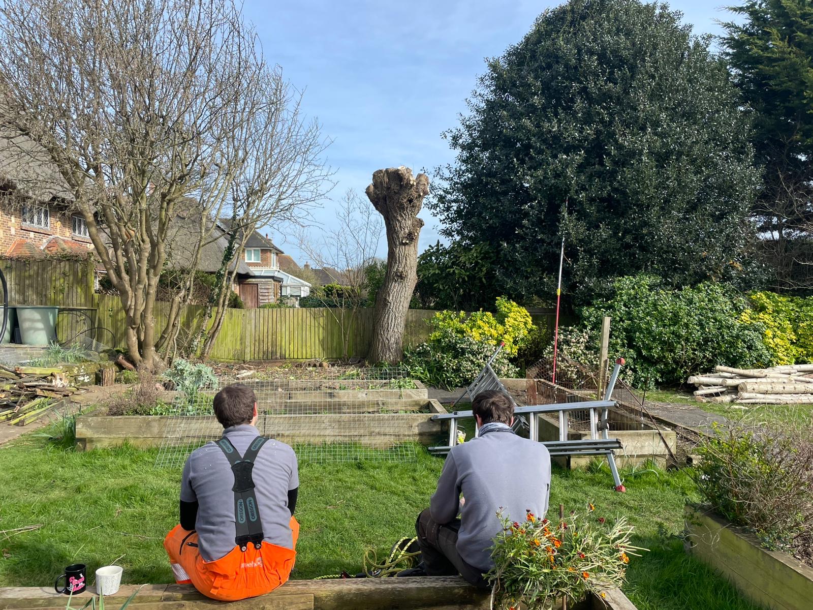 Two of the crew taking a break in a back garden after a pollard